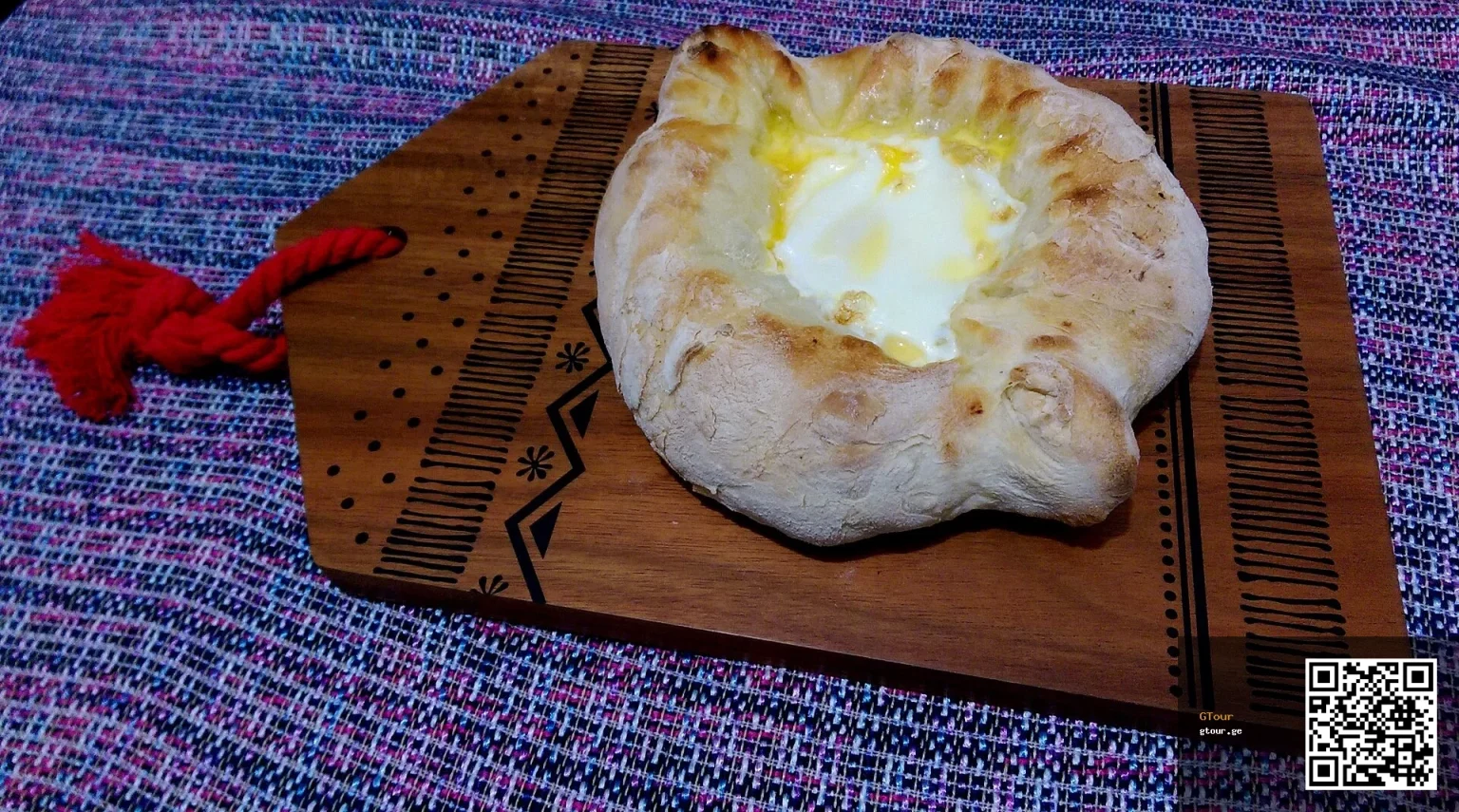 Adjaruli khachapuri, Georgia's iconic cheese-and-egg bread that Greek visitors should try.