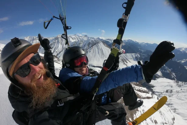Tandem paragliders soar over the snowy peaks above Gudauri ski resort.