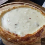 Khachapuri, Georgia's iconic cheese-filled bread, a dish Salvadoran visitors should try.