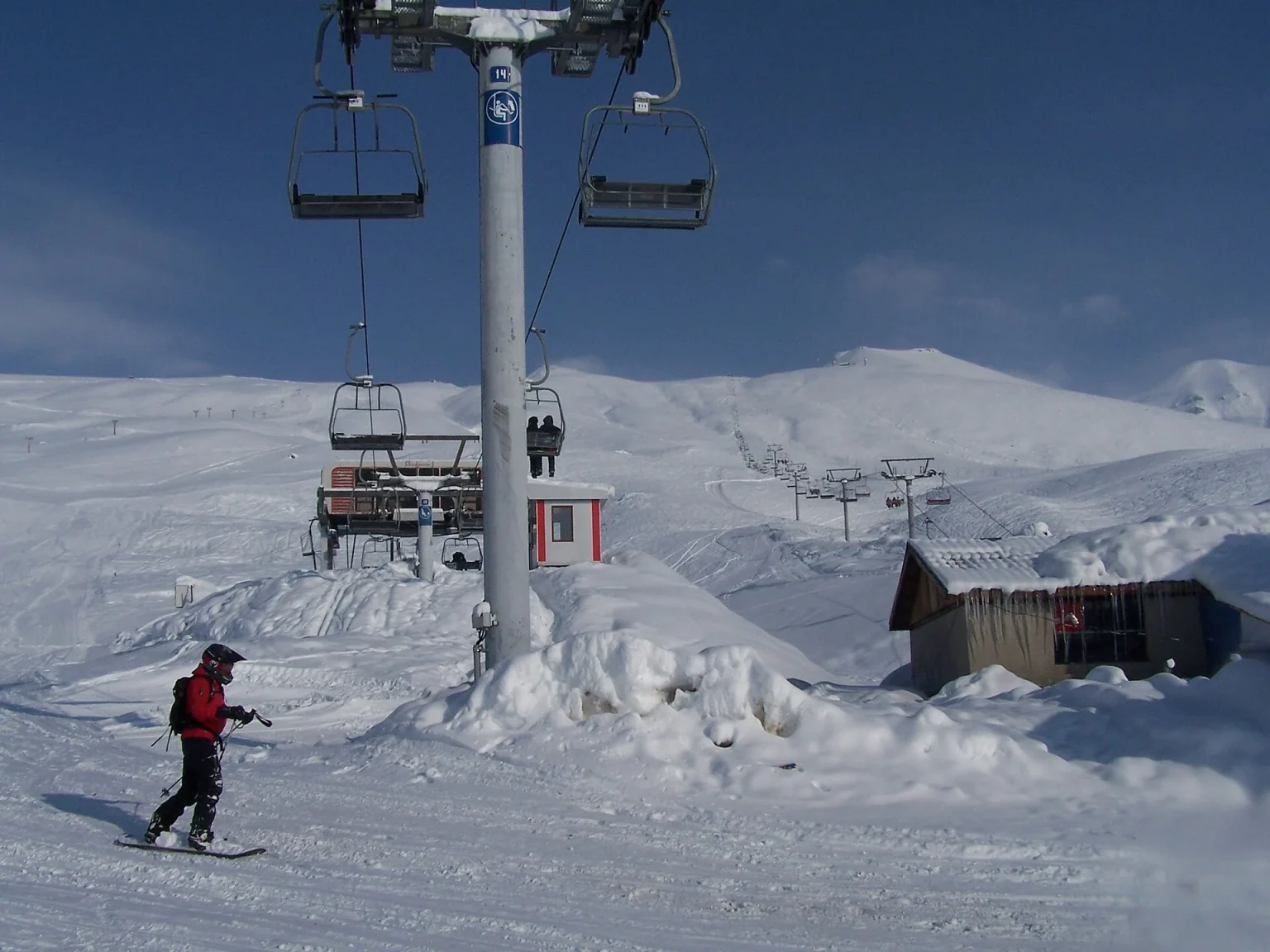 A skier descends the slope beneath a chairlift at Gudauri ski resort in winter.