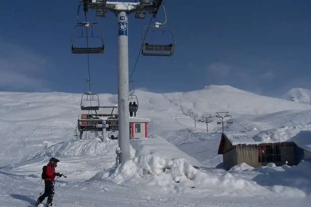 A skier descends the slope beneath a chairlift at Gudauri ski resort in winter.