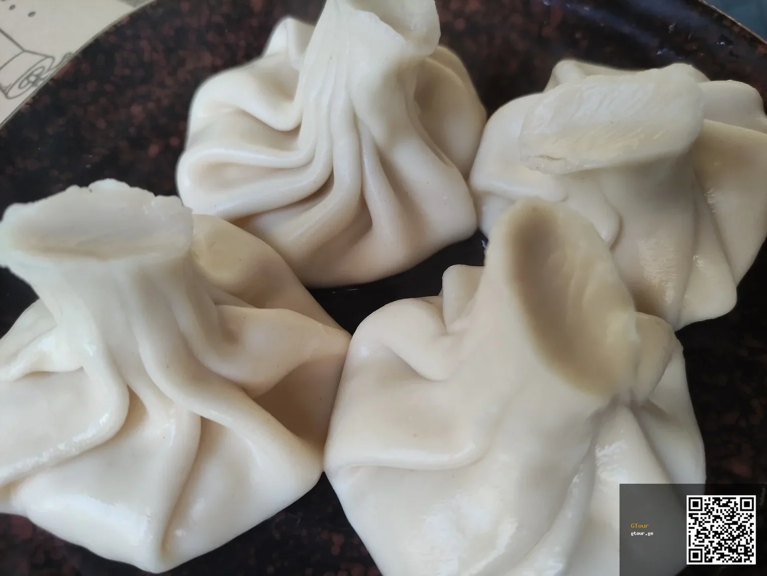 Khinkali, Georgia's iconic dumpling, a familiar dish Afghan travellers can easily enjoy.