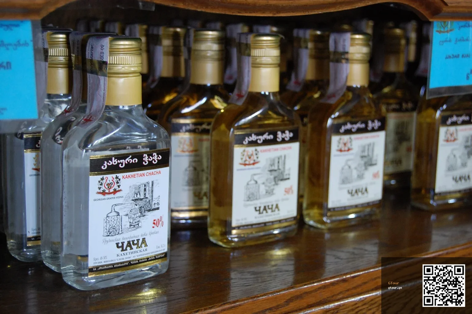 Bottles of Georgian chacha and wine lined up on a shop shelf in Kakheti.