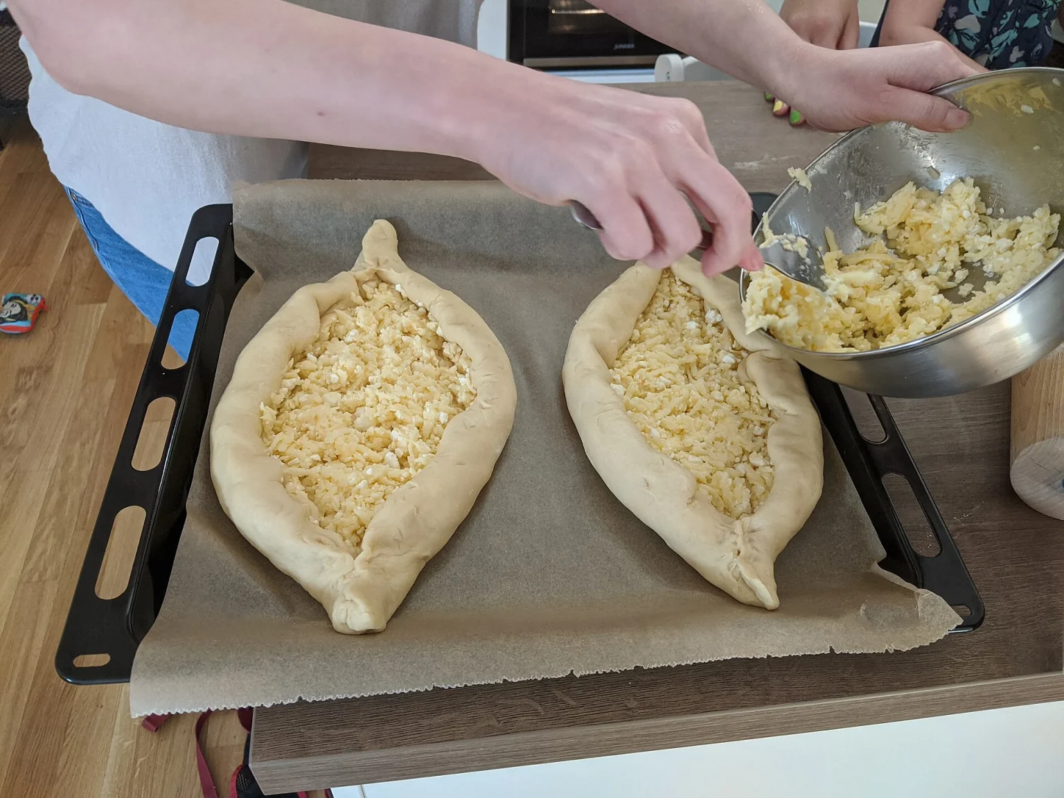 Adjarian khachapuri being filled with cheese, a classic Georgian dish for visitors to try.