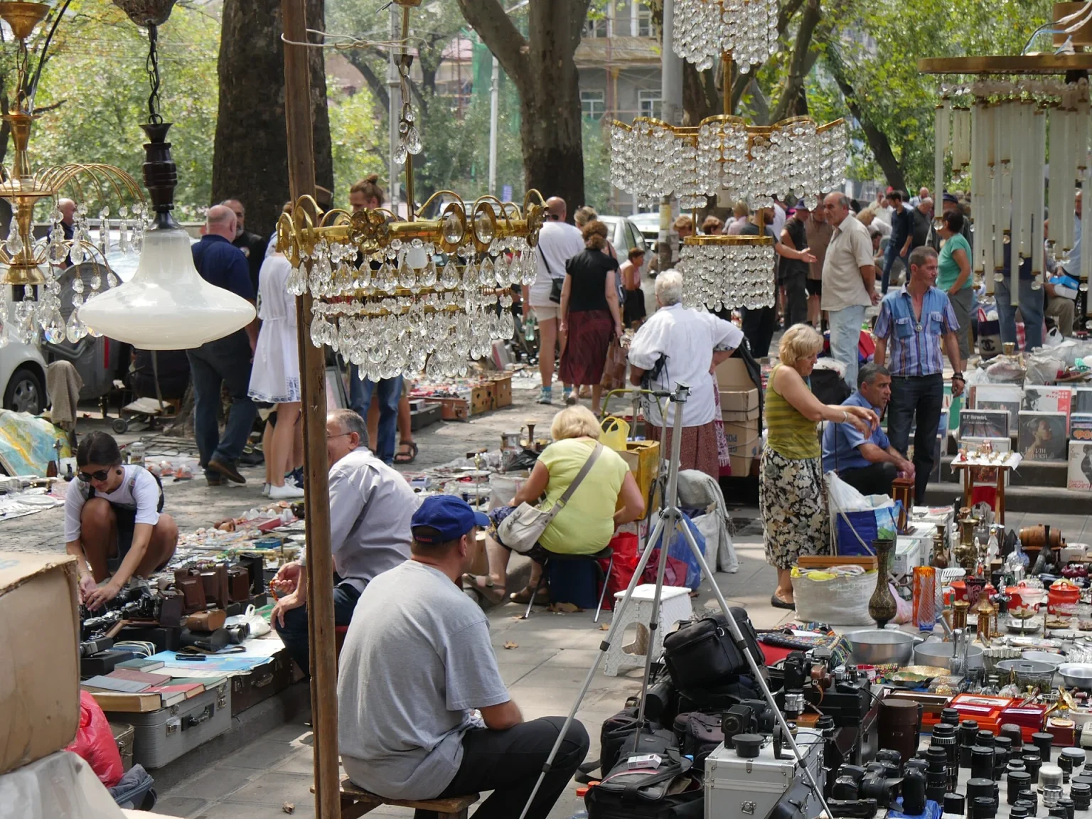 Visitors browse antiques and chandeliers at Tbilisi's famous Dry Bridge Market, a popular stop for travellers.