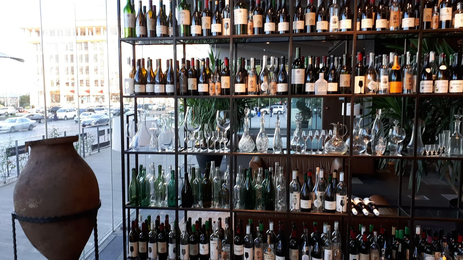A Tbilisi wine shop displays a traditional clay qvevri jar alongside shelves of Georgian bottles.