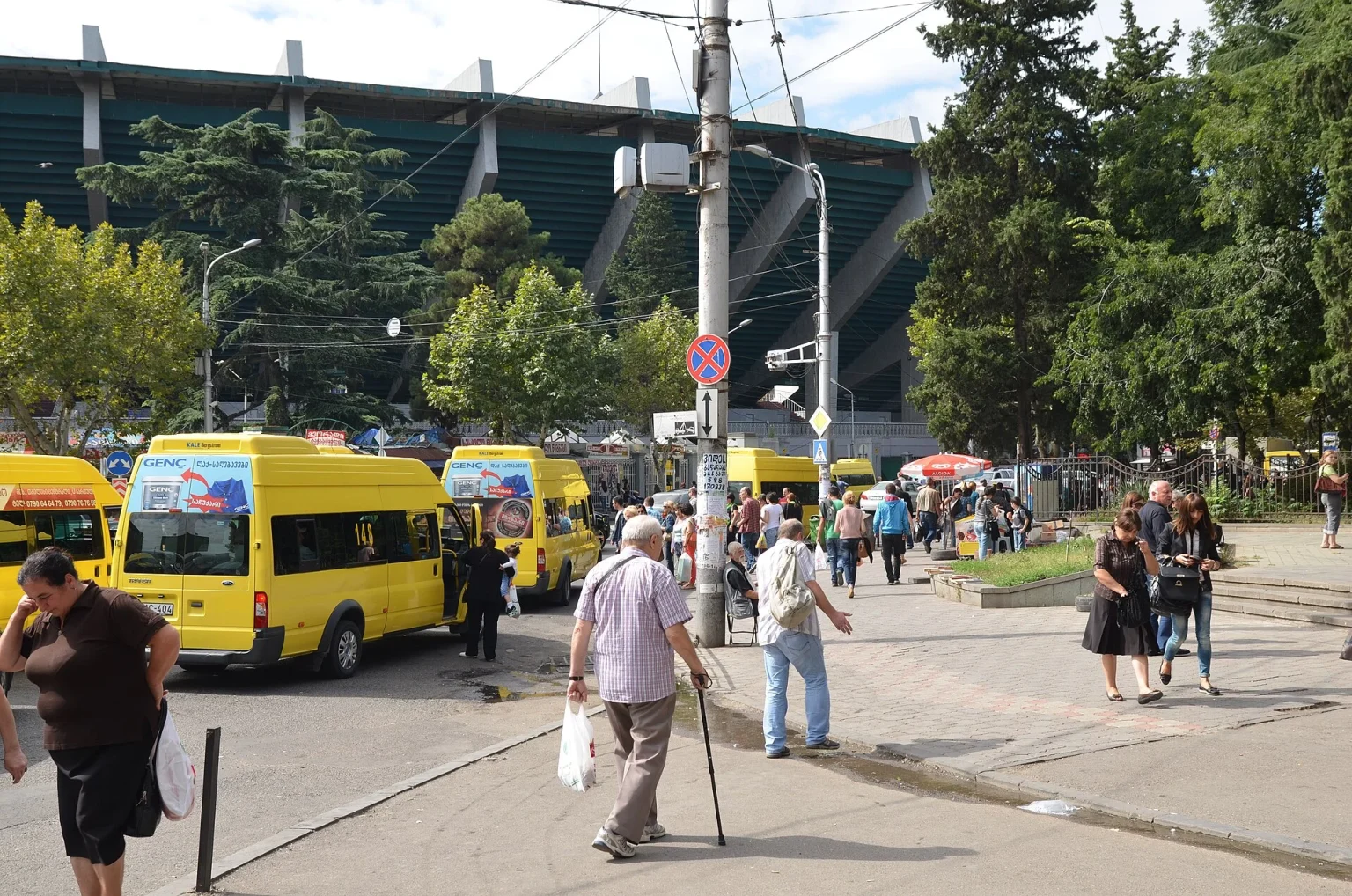 Yellow marshrutka minibuses wait at a Tbilisi stop near the central market.