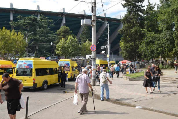 Yellow marshrutka minibuses wait at a Tbilisi stop near the central market.