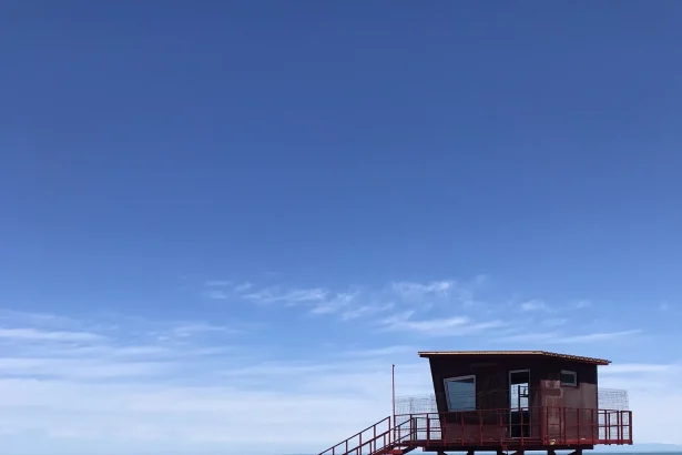A red lifeguard tower stands on Batumi's pebble beach by the Black Sea.