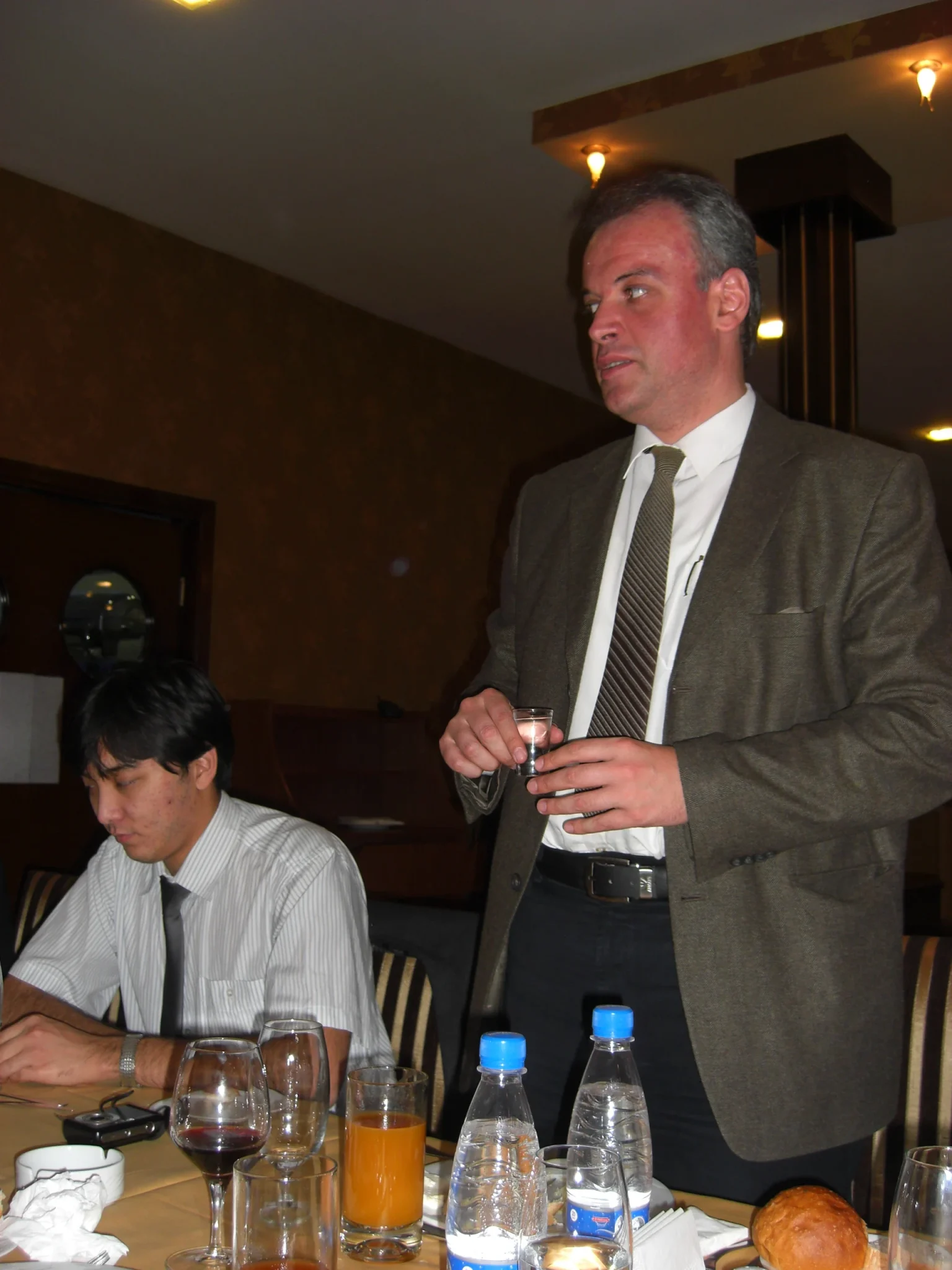 A modern-day tamada stands to deliver a toast, horn-glass in hand, at a Georgian supra.