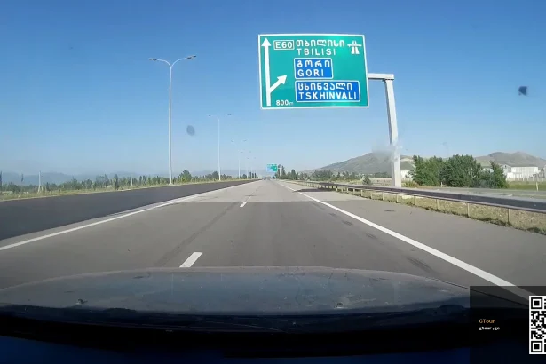 Highway sign near Tbilisi shows the E60 route and exits, typical of Georgia's road signage drivers must navigate.