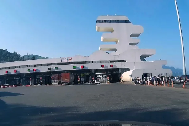 Vehicles and travelers queue at the futuristic Sarpi checkpoint on the Georgia-Turkey border.