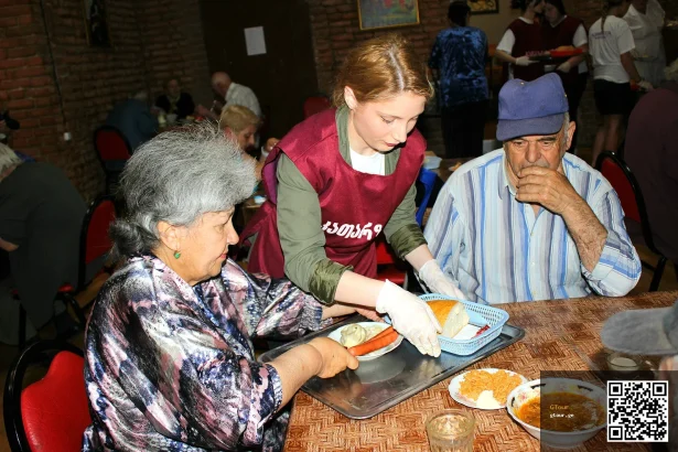 A waitress serves food to diners at a Tbilisi eatery, illustrating typical restaurant service where tips are given.